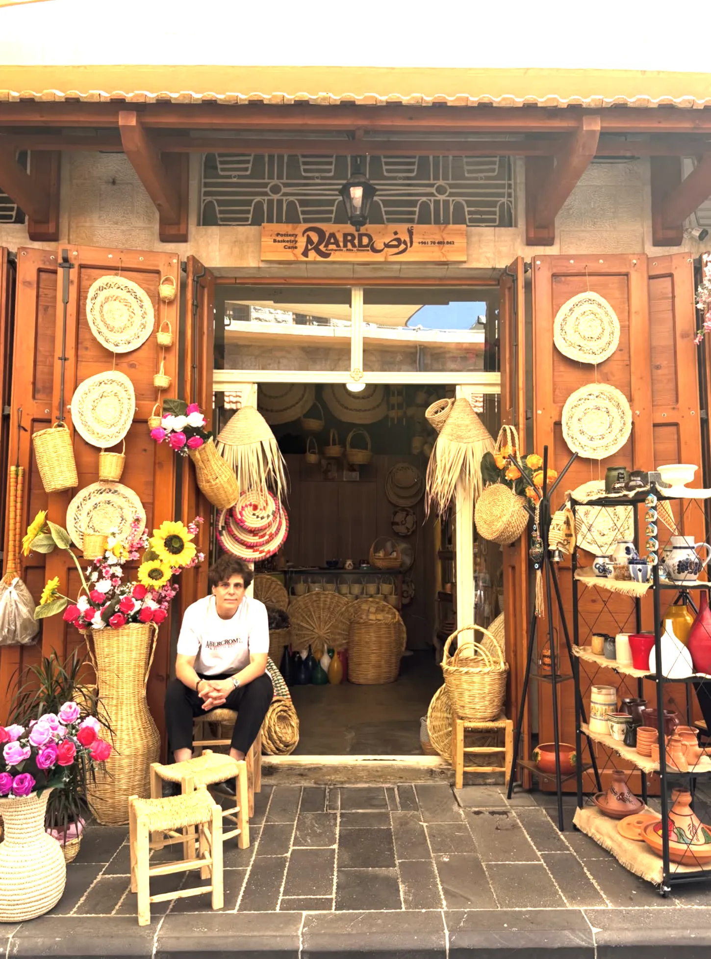 The ARD storefront in Douma, its owner seated among handmade baskets, reed crafts and pottery